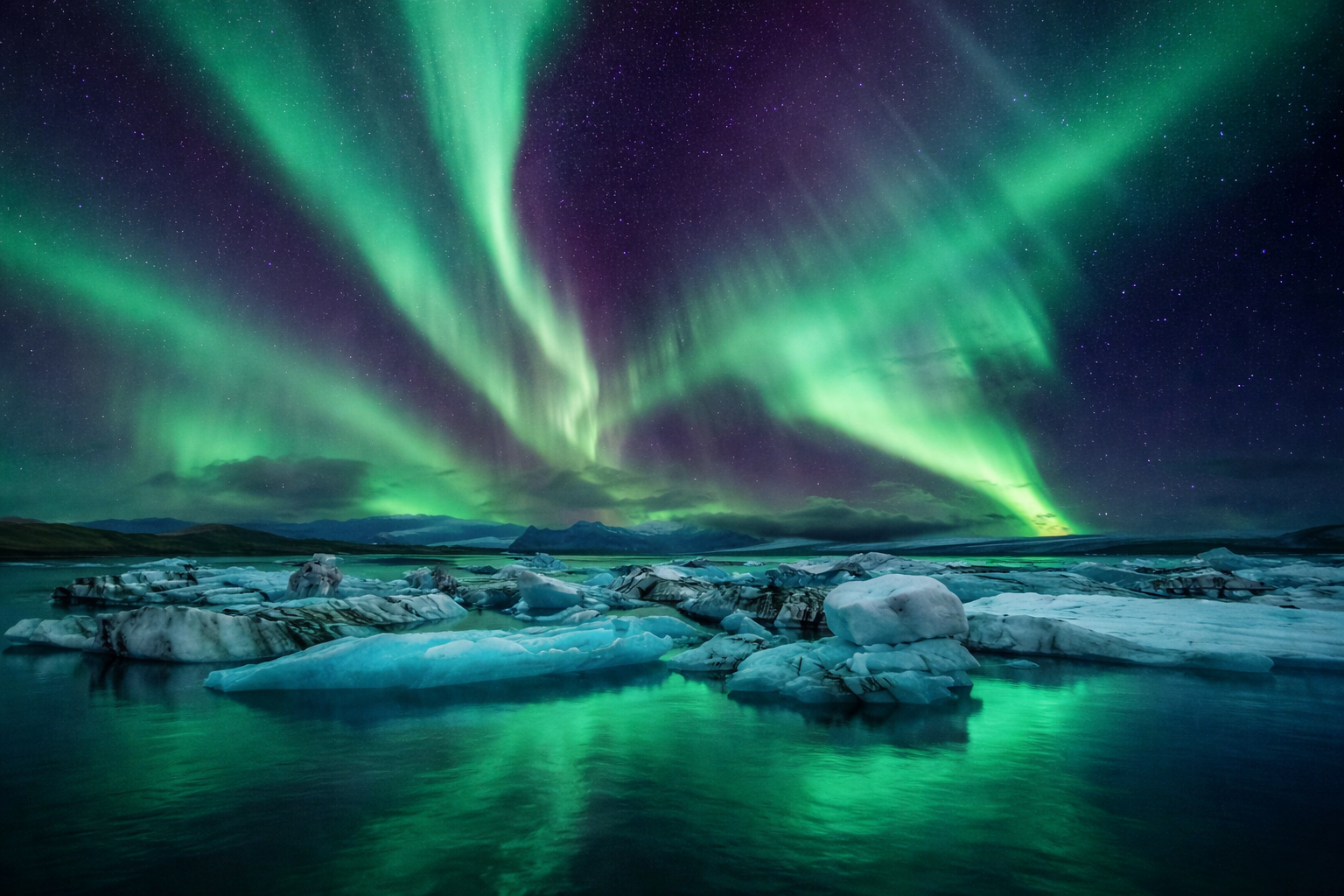 Northern lights over Jökulsárlón Glacier Lagoon with green reflections on the water
